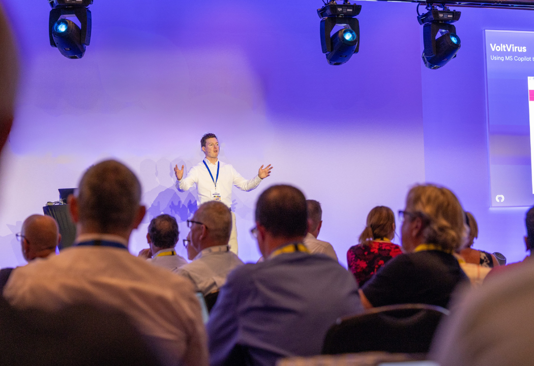 Michael James speaking on stage at a corporate AI training event